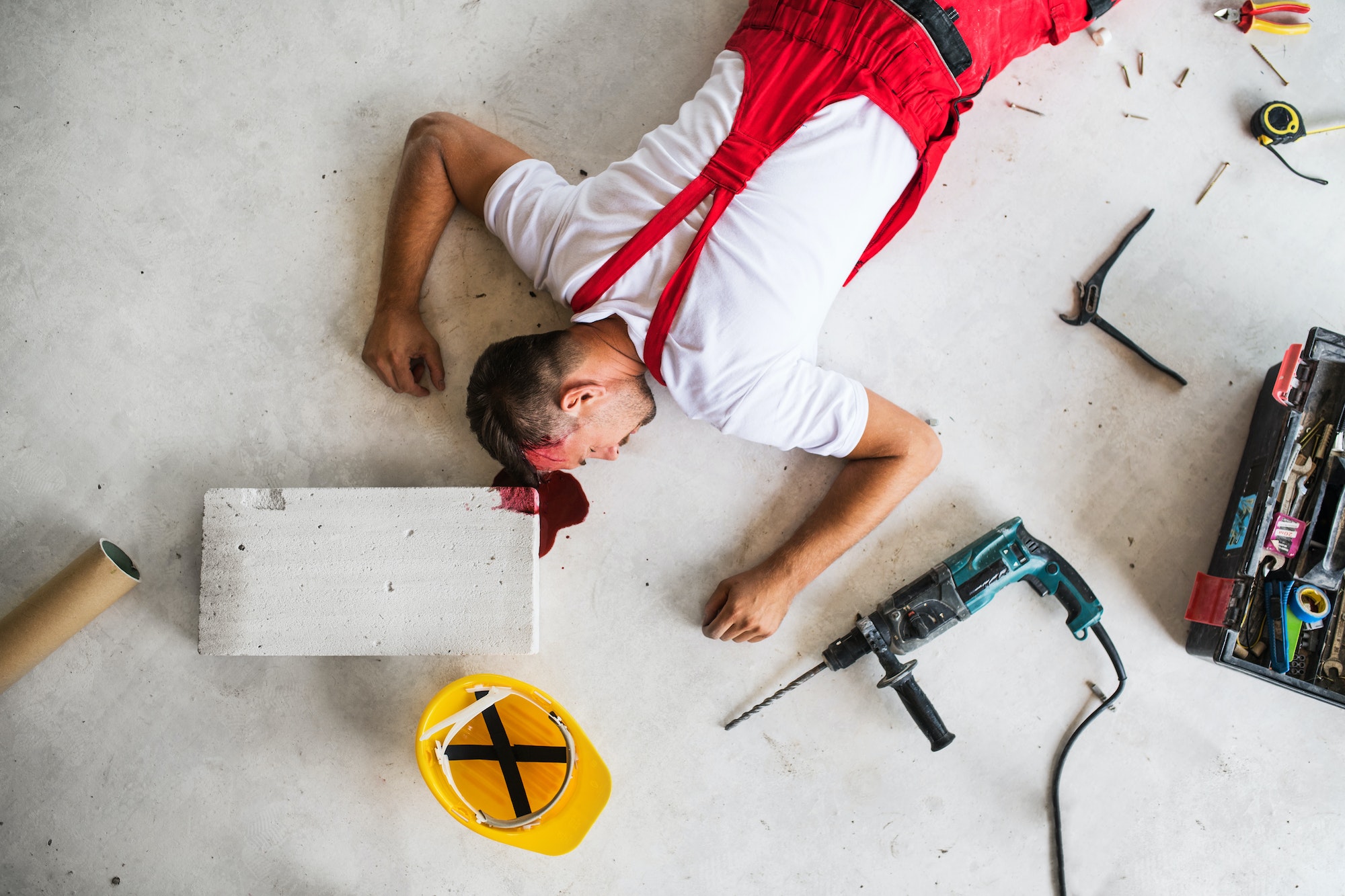 An unconscious man worker lying on the floor after accident on the construction site.