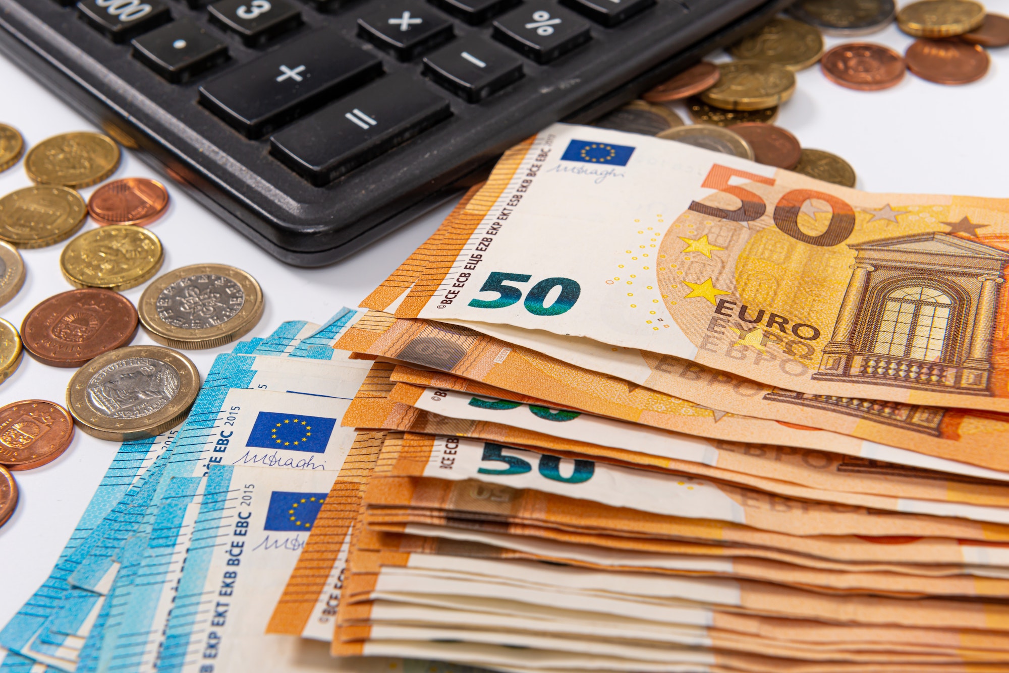 closeup of euro currency coins, banknotes and calculator, finance planning concept