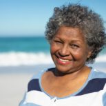 Old woman smiling at the beach