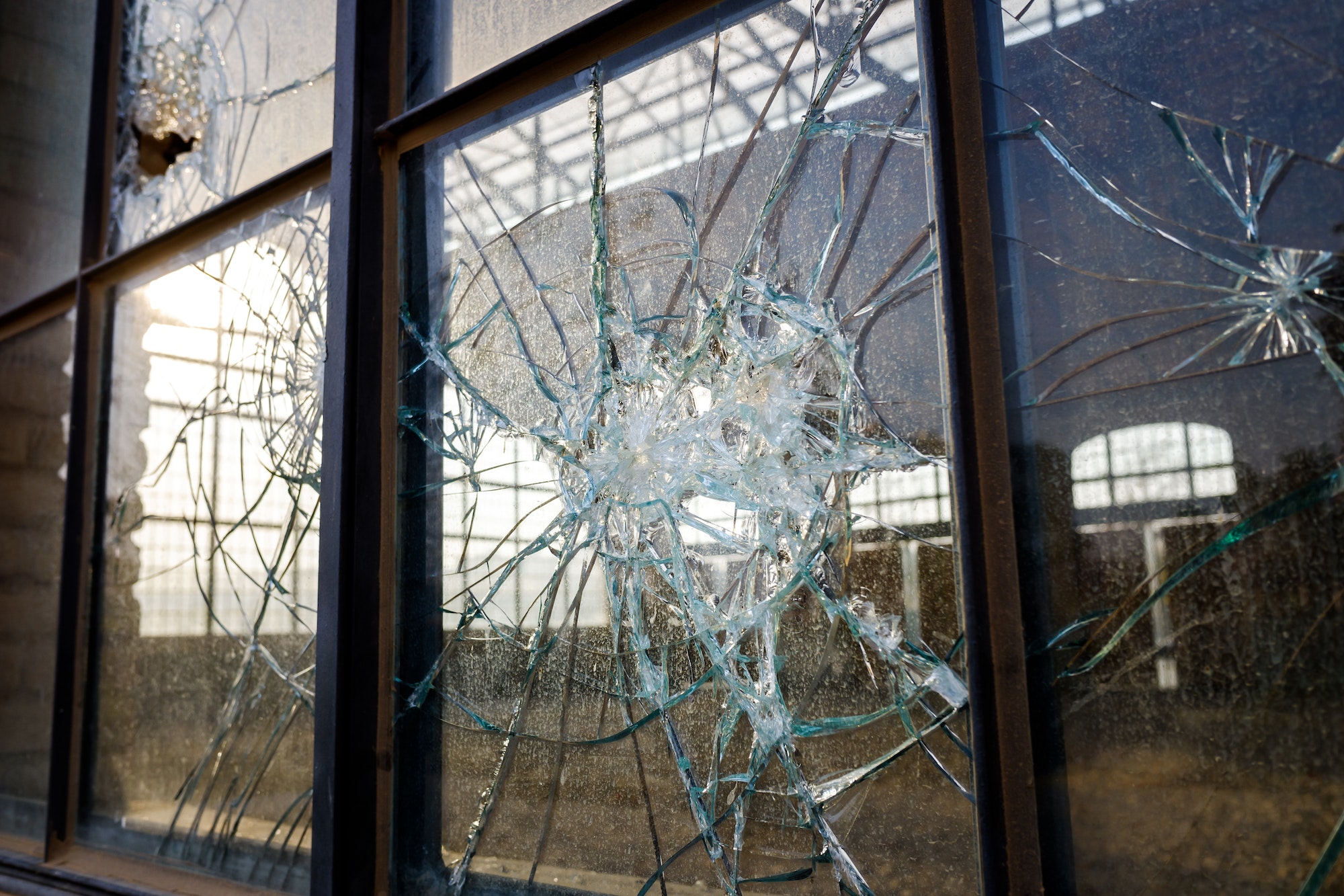 Thick broken glass of a window in an abandoned industrial zone.